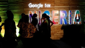 Reuters: Participants walk past glowing signs during a conference tagged
