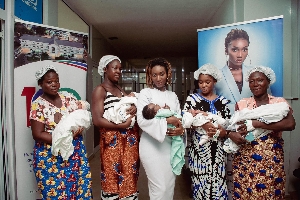 Wendy Shay flanked by new mothers at the Korle Bu Teaching Hospital, Accra