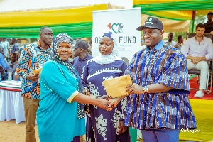 Alhassan Suhuyin making a presentation to a woman