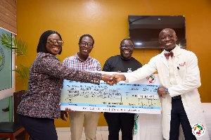 Obuobia Darko Opoku presenting the cheque to a patient