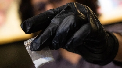 A person holds a bag of cocaine, to be tested for adulterated substances, during a techno party in the outskirts of Bogota, Colombia, on November 19, 2021. Juan Pablo Pino/AFP/Getty Images/File