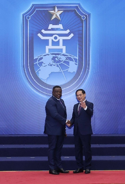 Sam George shaking with officials at the conference