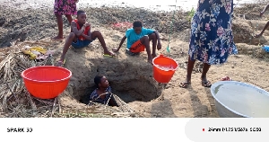 Children looking for water in dug outs in Prampram