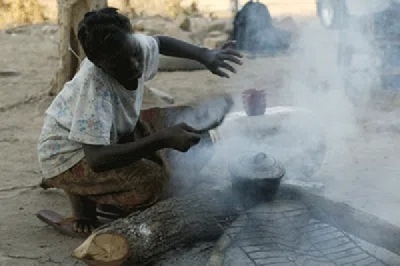 Woman using fire  wood to cook