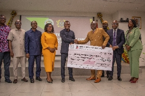 Alhaji Seidu Agongo, founder of Alive Industries, presenting a cheque for GHS500,000 to Health Minister Kwabena Mintah Akandoh, during the pledge redemption ceremony in Accra