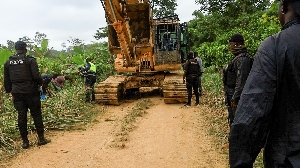 Police trying to move the excavator during the operation in the forest reserve