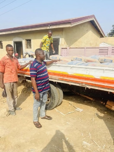 Workmen of Mr Patrick Boamah offloading the cement from the Kia  truck