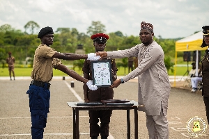 Abubakari Saana Abdul-Kudus handing a certificate to a graduate at the ceremony
